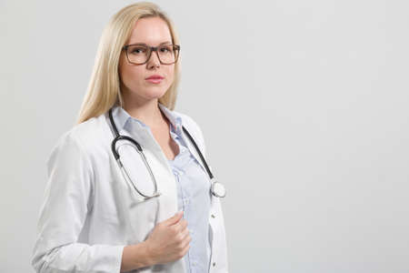 Female friendly young family doctor in doctor's overall with stethoscope