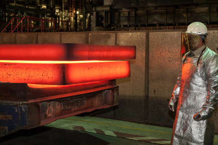a steel worker and a red glowing slap in a steel mill