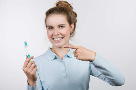 smiling female teenager is pointing to her tooth brushの写真素材