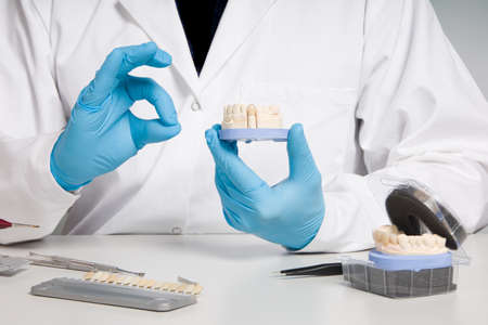 Dentist's / dental technician's hand in gloves are presenting a dental imprint with artificial...