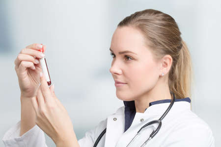 young female doctor or scientist is handling a blood sampleの写真素材