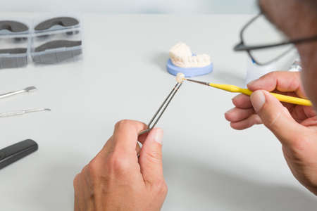 close up of coloring work on denture parts in dental laboratory