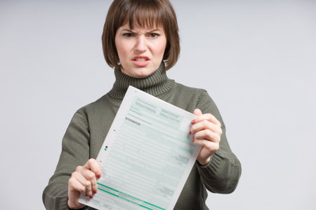 woman holding an empty tax form and makes a wry face