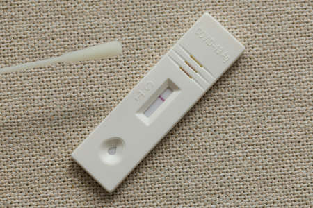 Close up of a negative antigen express self-test with cotton swap on a cloth surfaceの写真素材