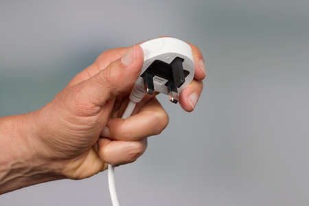 Hand is holding an electrical plug
