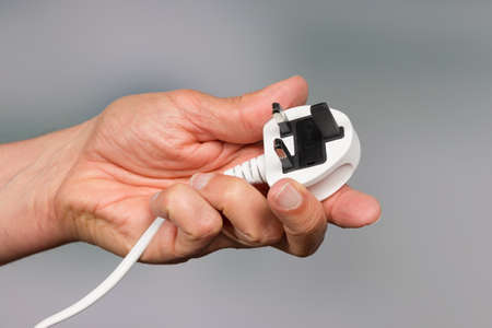 Hand is holding an electrical plug
