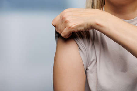 Close up of a female arm with turned up sleeve and ready for vaccinationの写真素材