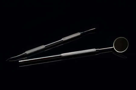 Close up of dental instruments for prophylaxis examination on a black shiny surfaceの写真素材