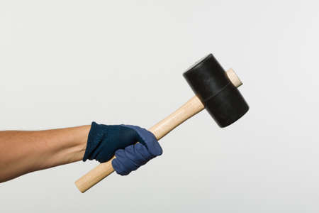 Hand in working gloves handling a hammerの写真素材