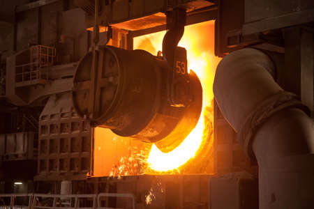 A Bessemer converter in a steel mill is being fed with liquid iron