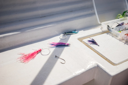 Fishing tackle - fishing line, hooks and lures on white background. On the boat.