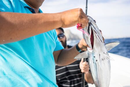 Close up of hands holding a fish that was caught. Fishing on open water from the boat. Beautiful...