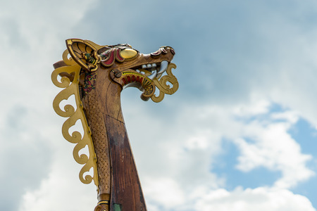 Old-fashioned viking ship, a vintage sail ship with a dragon head carving during a sunny day.の写真素材