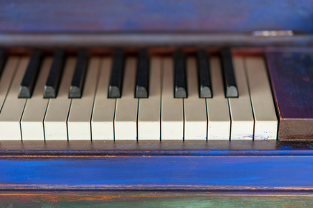 Vintage painted colorful piano and black and white keys. Artistic blue and purple brush strokes, classical music instrument.の写真素材