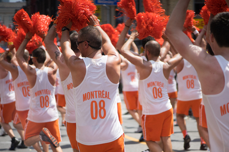 June 29, 2014, Toronto, Canada. Group of male performers dressed in orange Montreal jerseys performing a cheerleading routine. Supporting marriage equality and LGBT rights during the Pride Parade.のeditorial素材