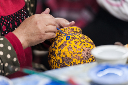Workshop making enamel items such as bowls, vases and other home decor items in Beijing, China. Shots of porcelain enamel paint made from powdwred glass applied to metal surfaces.の写真素材