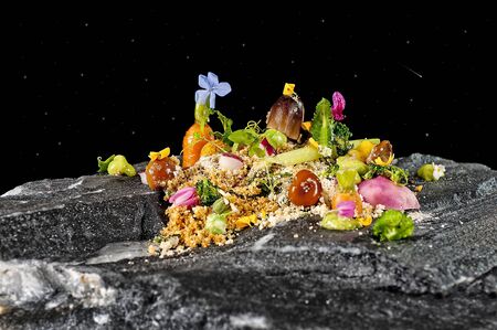 ensalada minimalista emplatada en roca.の写真素材