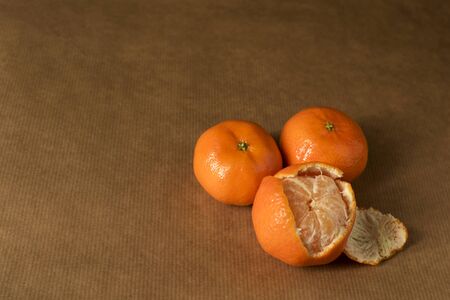 Three clementines on brown paperの写真素材