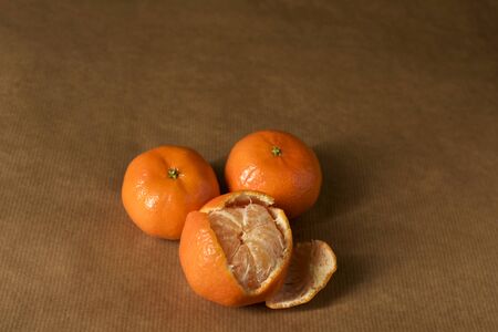 Three clementines on brown paperの写真素材