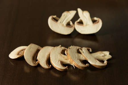 Studio shot of an arrangement of sliced brown mushrooms - dark backgroundの写真素材