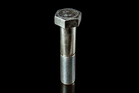 An isolated steel bolt on black backgroundの写真素材