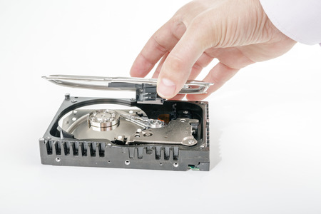 Hand repairman opens the top cover of the 3.5 inch HDD. Isolated on white background.の写真素材