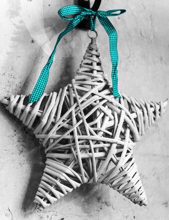 star from a tree with a blue tape against the background of a wallの写真素材