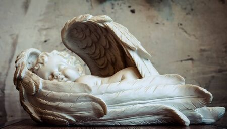 angel figurinÑ of an angel against the background of a white wall Christmas decor, white countertop, white wall, bokeh, background,の写真素材