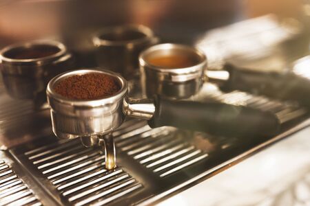 two coffee holders one with ground coffee near professional coffee machine close up, barista tools.の写真素材