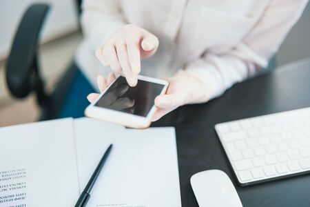 woman's hands typing message in smartphone while working in office , business concept.