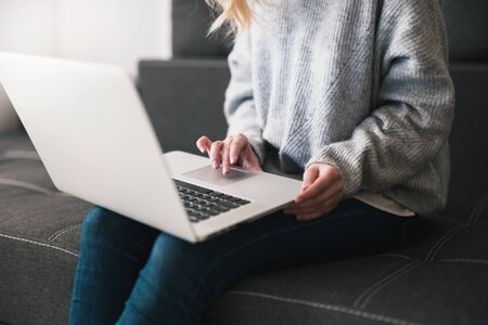 woman manager sits on the sofa typing at her laptop , cozy office atmosphere concept.
