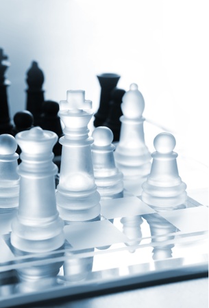 Black and white transparent pieces of chess on board made of glass の写真素材