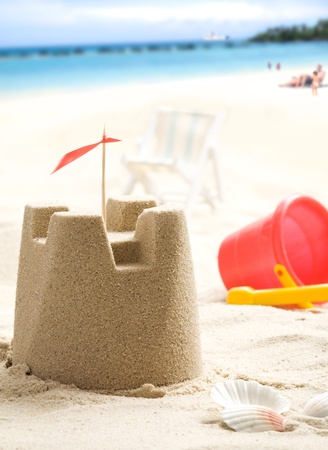 Sand castle on the beach  People and sea in backgroundの写真素材