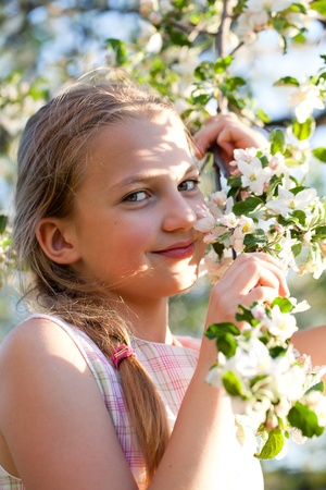 Happy young girl in a garden with white apple flowersの写真素材