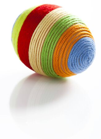 Easter egg with colorful woolen yarn on white background  Space for textの写真素材