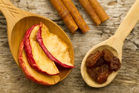 dried apples with cinnamon sticks and raisins on the old wooden background. Closeup.の写真素材