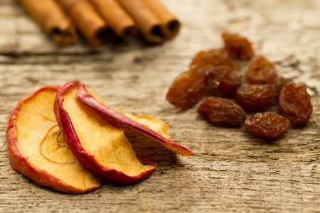 dried apples with cinnamon sticks and raisins on the old wooden background. Closeup.の写真素材