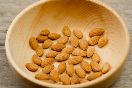 peeled almonds in a plate on wooden background. For vegetariansの写真素材