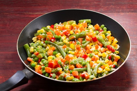 vegetable mix in the pan on wooden backgroundの写真素材