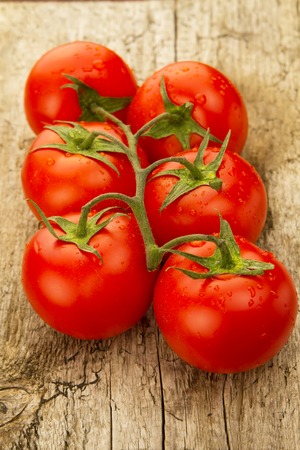 few red tomatoes branch on wooden backgroundの写真素材