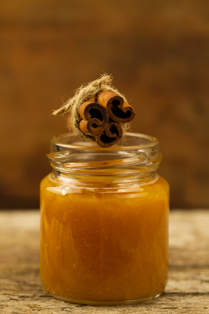 small jar of fresh honey with cinnamon on wooden backgroundの写真素材