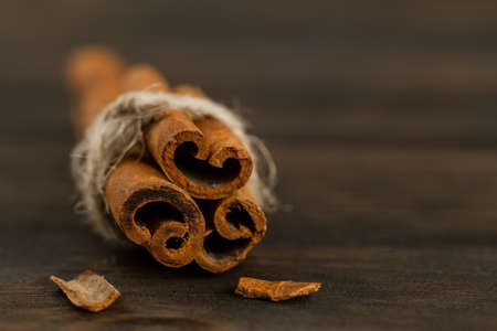 cinnamon sticks on wooden background, close upの写真素材