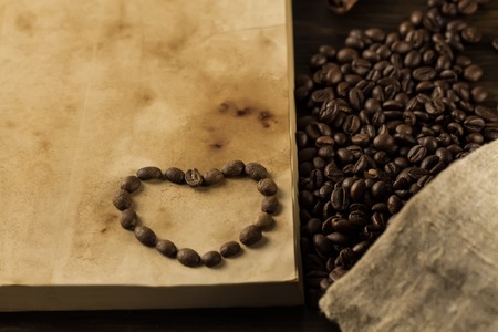 roasted coffee beans on old vintage open bookの写真素材