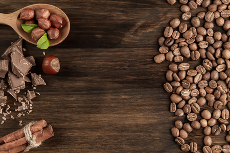 shelled hazelnuts, roasted coffee beans, cinnamon on wooden background, close upの写真素材