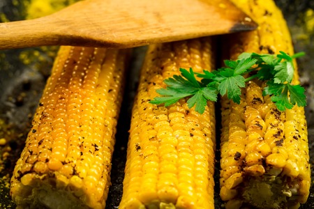 fried corn in a skillet with spices on wooden backgroundの写真素材