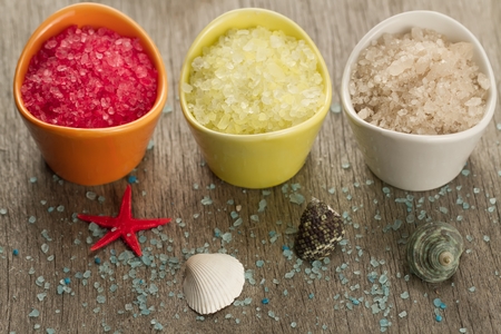 Colorful sea salts and seashells for the bathroom on wooden backgroundの写真素材