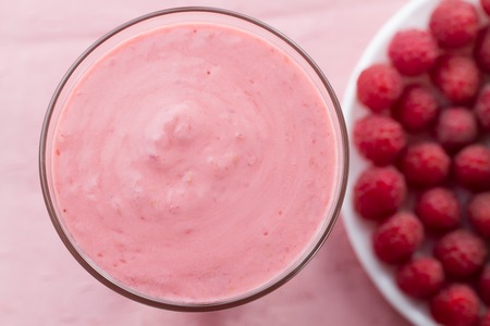 Raspberry smoothie with berries on wooden background
