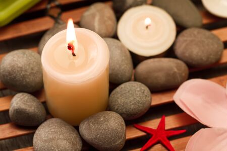 Spa composition with sea salt, candles, soap, shells, creams for face on wooden backgroundの写真素材