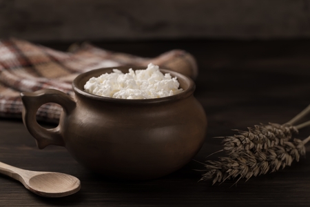 fresh tasty curd in pot on wooden backgroundの写真素材
