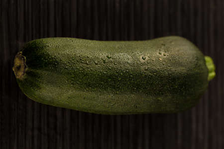 zucchini with water drops on dark backgroundの写真素材